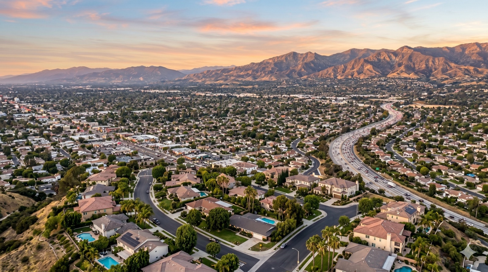 Aerial view of a San Fernando Valley neighborhood at sunset with the surrounding mountains